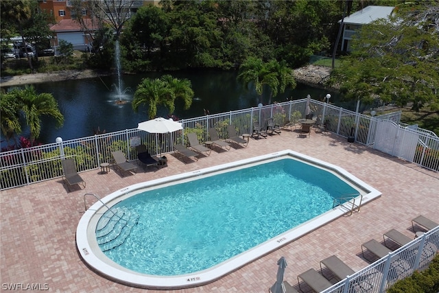 view of pool with a patio and a water view