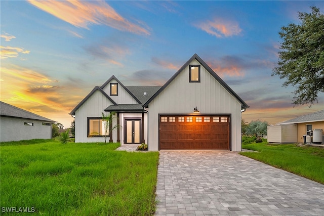 modern farmhouse style home with a garage and a lawn