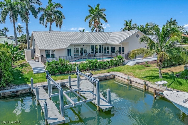 back of house with a yard, a water view, and a patio