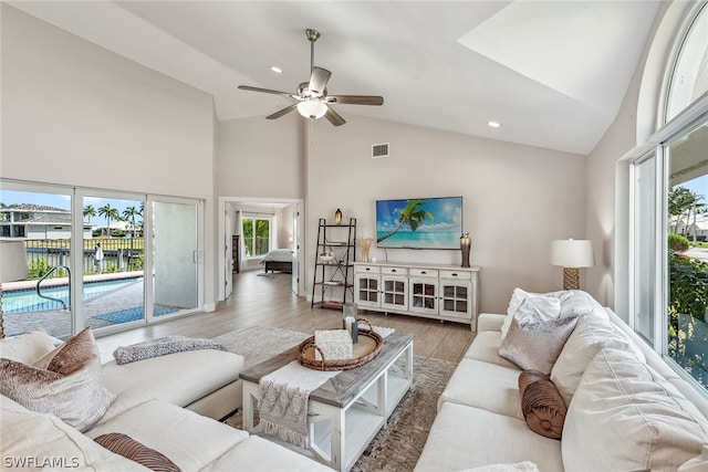 living room featuring wood-type flooring, high vaulted ceiling, plenty of natural light, and ceiling fan