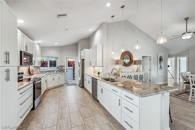 kitchen featuring hanging light fixtures, backsplash, kitchen peninsula, and stainless steel appliances