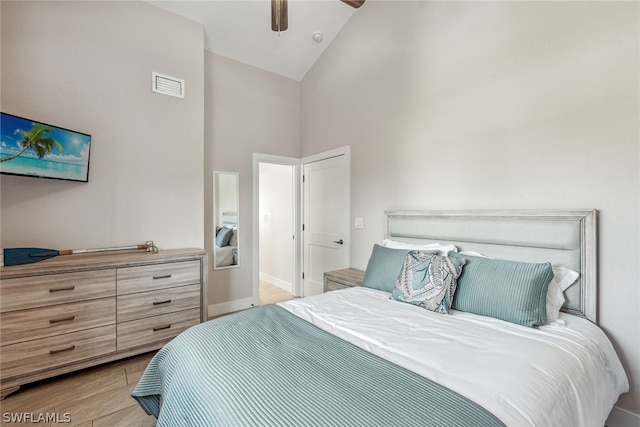 bedroom with high vaulted ceiling, light hardwood / wood-style floors, and ceiling fan