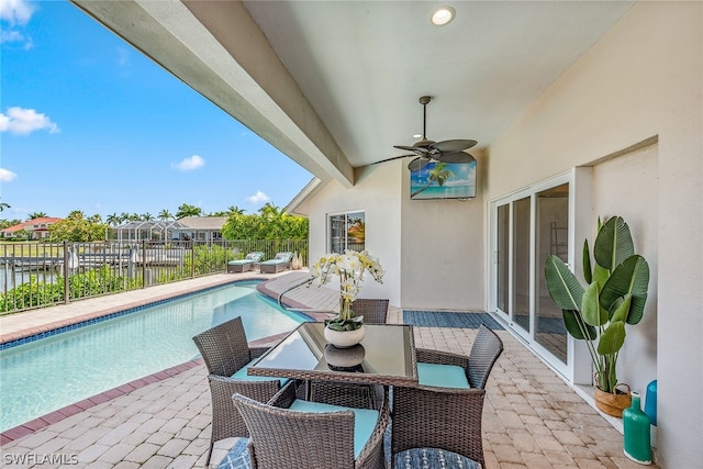 view of terrace featuring ceiling fan and a fenced in pool