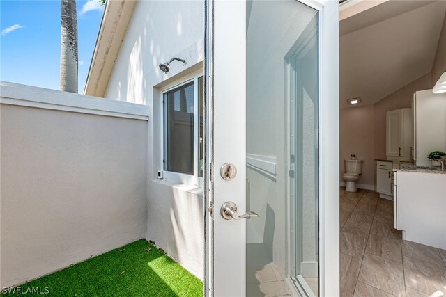 bathroom featuring tile floors, a shower with door, and vaulted ceiling