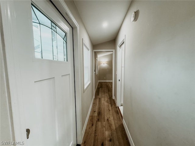 hall with vaulted ceiling and dark hardwood / wood-style flooring