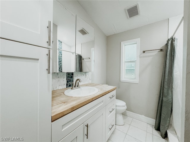 bathroom with backsplash, vanity with extensive cabinet space, tile flooring, and toilet