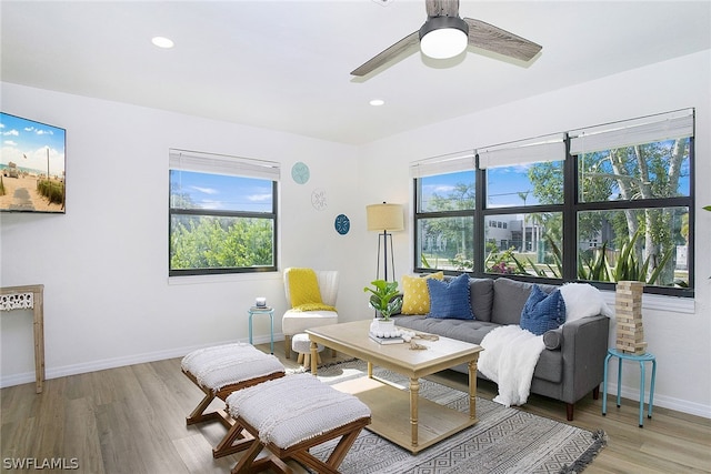 living room with a wealth of natural light, wood-type flooring, and ceiling fan