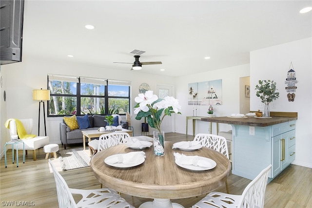 dining space featuring ceiling fan and light wood-type flooring