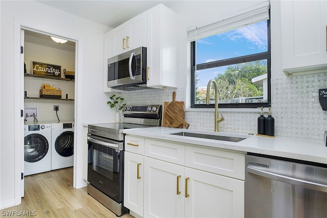 kitchen featuring backsplash, appliances with stainless steel finishes, sink, and independent washer and dryer