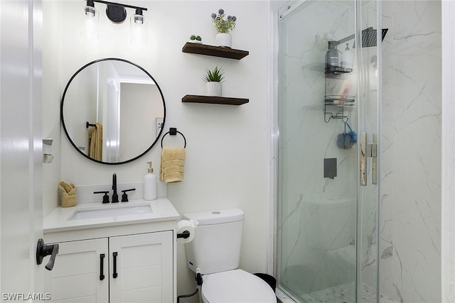 bathroom with a shower with shower door, toilet, and vanity with extensive cabinet space