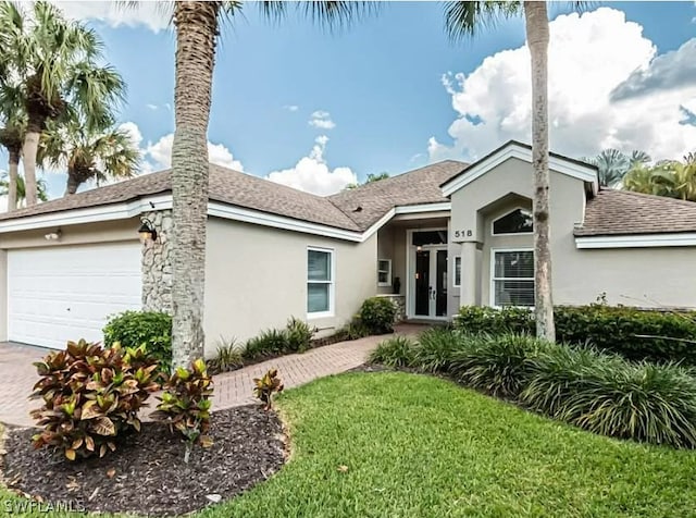 view of front of property with a garage and a front lawn