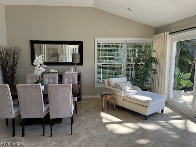 tiled dining space featuring lofted ceiling