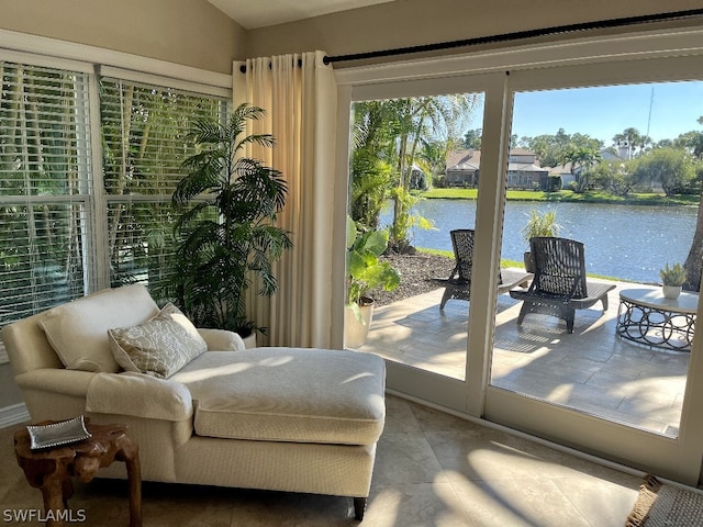 living area with tile floors, plenty of natural light, and a water view