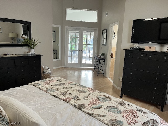 bedroom with french doors, a high ceiling, light hardwood / wood-style flooring, and access to exterior