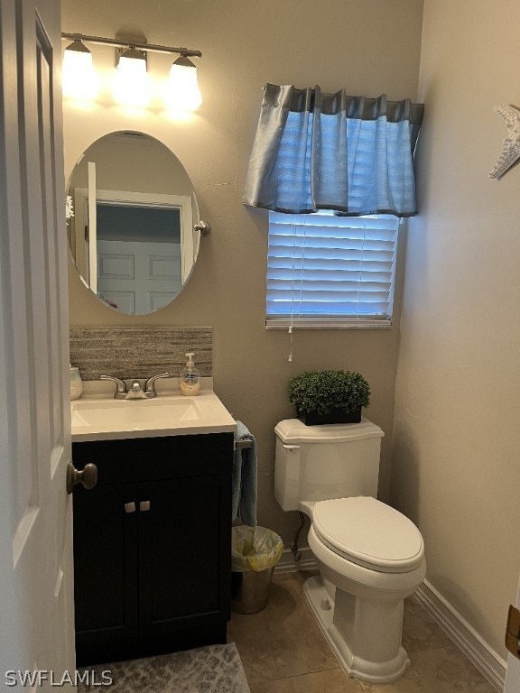 bathroom with tile flooring, vanity, and toilet