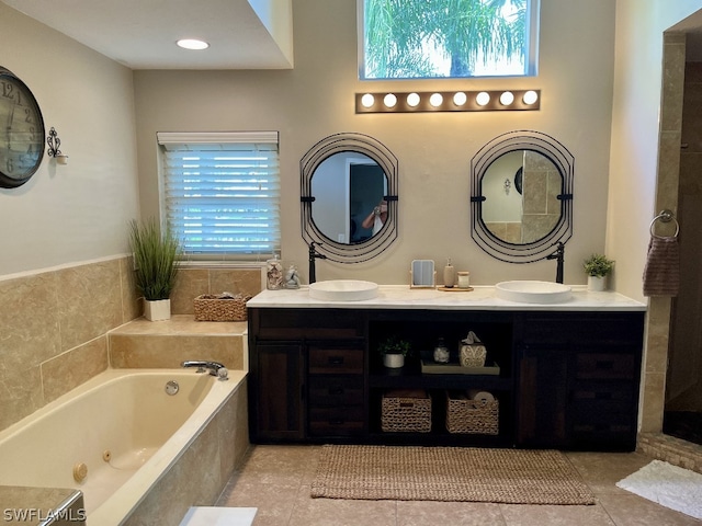 bathroom with double vanity, a bath, and tile floors