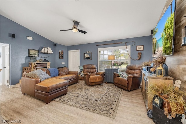 living room with ceiling fan, light hardwood / wood-style flooring, and vaulted ceiling