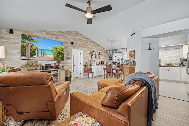 living room featuring ceiling fan, lofted ceiling, and light wood-type flooring