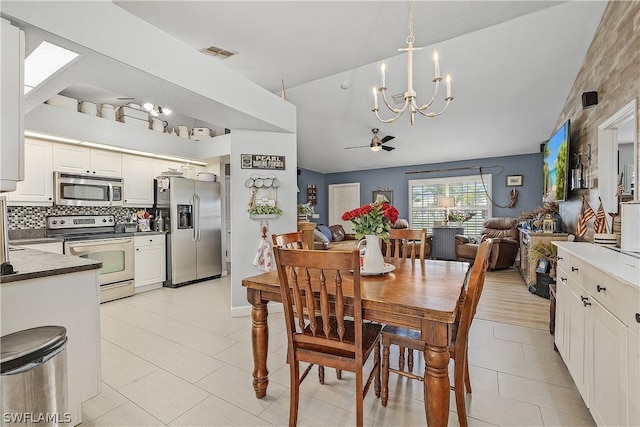 dining space featuring light tile patterned floors and ceiling fan with notable chandelier