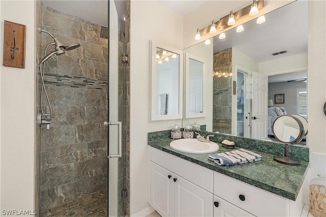 bathroom featuring a shower with door and vanity