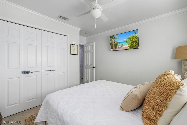 carpeted bedroom with a closet, ceiling fan, and ornamental molding