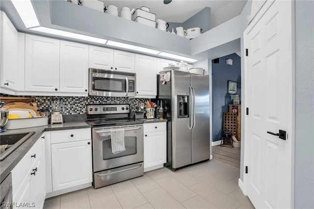 kitchen featuring tasteful backsplash, white cabinets, and appliances with stainless steel finishes