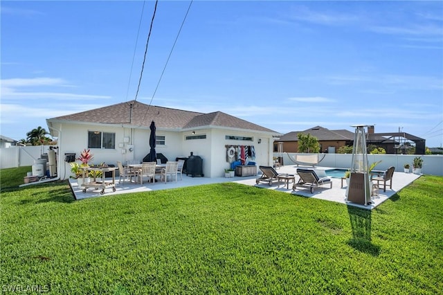 rear view of house with a lawn and a patio