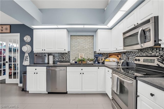 kitchen with white cabinets, appliances with stainless steel finishes, backsplash, and sink