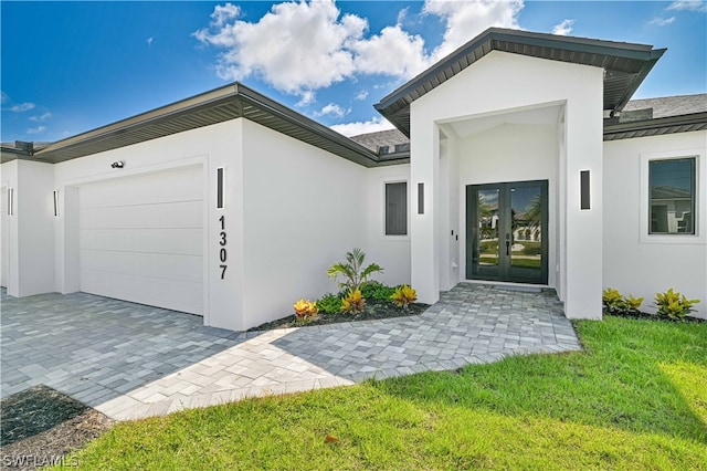 exterior space featuring a garage, french doors, and a lawn