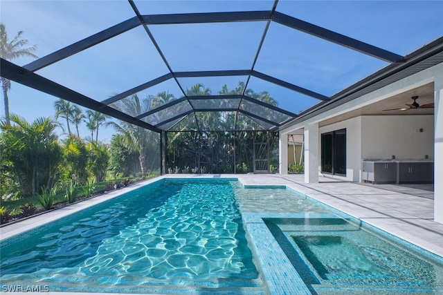 view of swimming pool featuring ceiling fan, glass enclosure, and a patio area