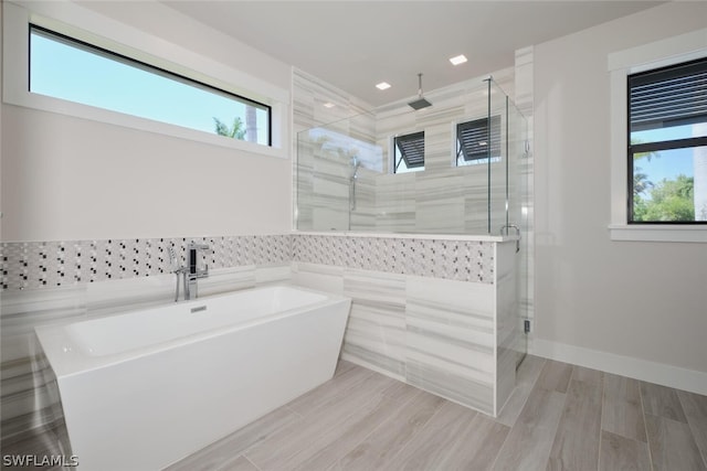 bathroom with independent shower and bath and tile walls