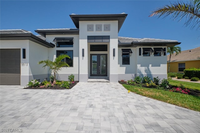 view of front facade with a garage and french doors