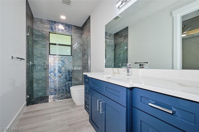 bathroom with ceiling fan, toilet, tile floors, an enclosed shower, and vanity