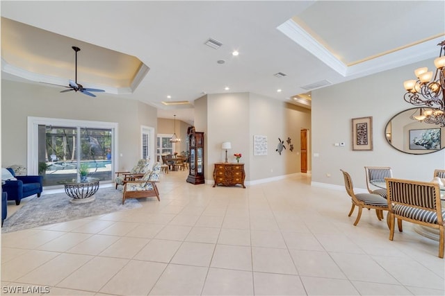 living room featuring light tile patterned floors, ceiling fan with notable chandelier, visible vents, baseboards, and a tray ceiling