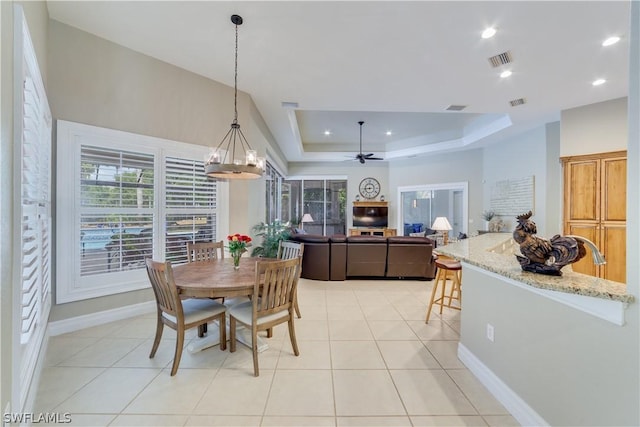 dining area featuring a raised ceiling, visible vents, baseboards, and light tile patterned floors