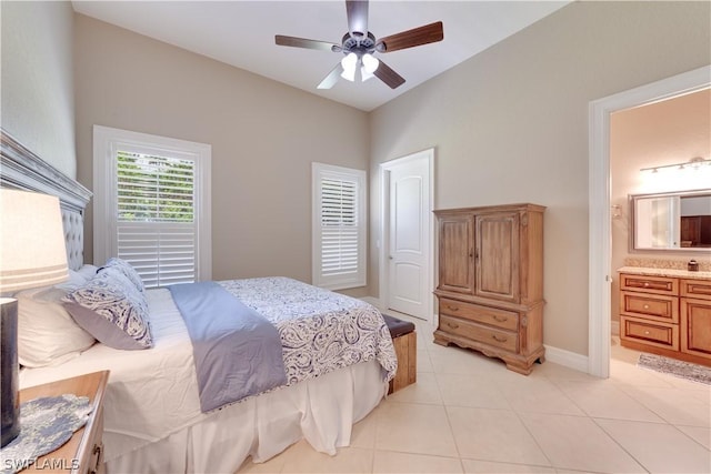 bedroom featuring a ceiling fan, light tile patterned flooring, baseboards, and ensuite bathroom