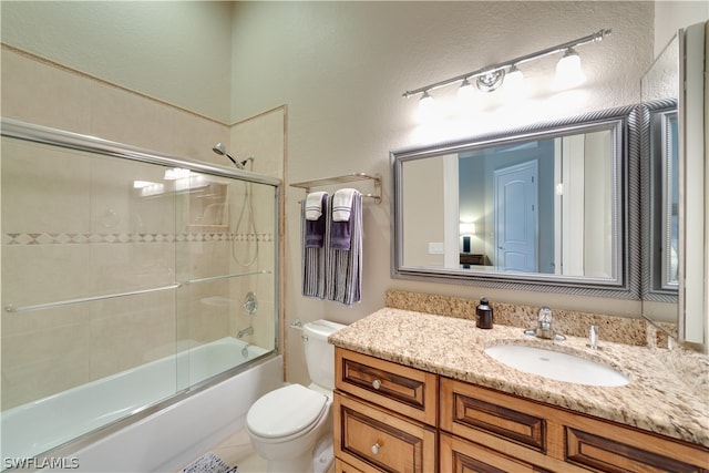 full bathroom featuring vanity with extensive cabinet space, enclosed tub / shower combo, and toilet