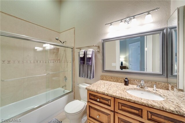 full bathroom with toilet, shower / bath combination with glass door, and vanity