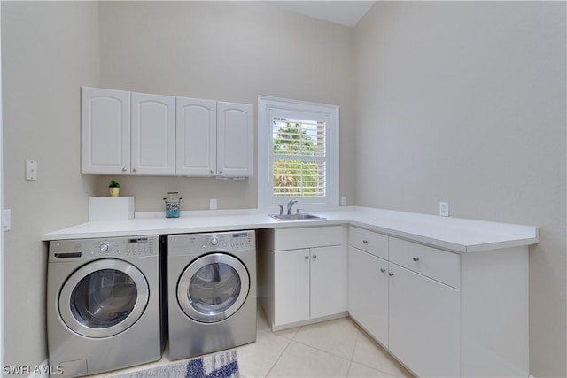 clothes washing area featuring a sink, light tile patterned floors, washing machine and clothes dryer, and cabinet space