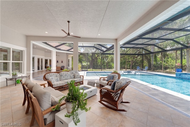 view of pool featuring glass enclosure, an outdoor hangout area, a patio area, and ceiling fan