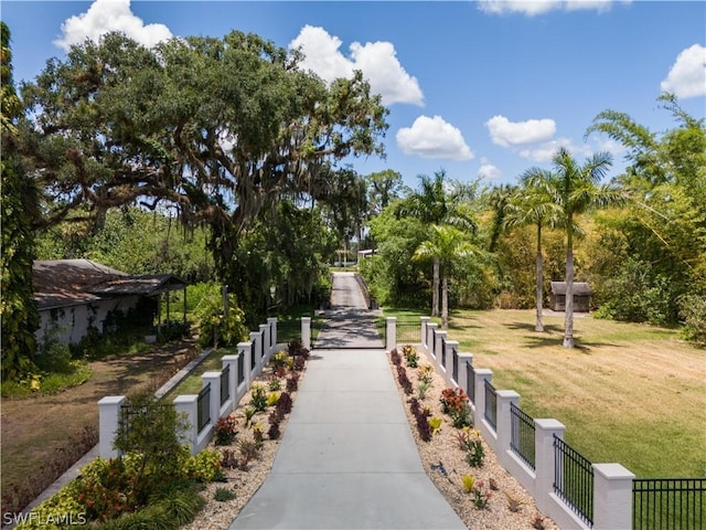 view of home's community with fence and a yard