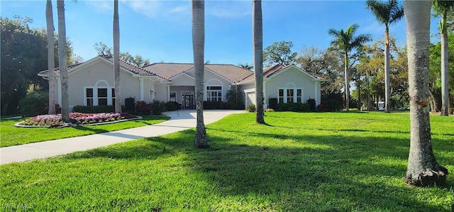 view of front facade with concrete driveway, a front lawn, an attached garage, and stucco siding