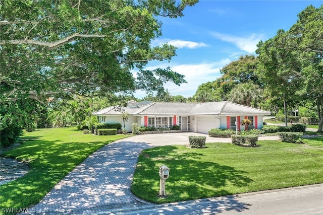 ranch-style home with a garage and a front lawn