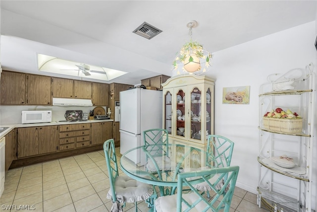 tiled dining room with a skylight and ceiling fan