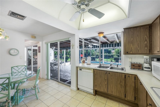 kitchen featuring light tile patterned floors, white appliances, plenty of natural light, and sink