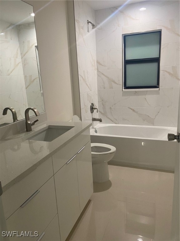 full bathroom featuring toilet, vanity, and tiled shower / bath