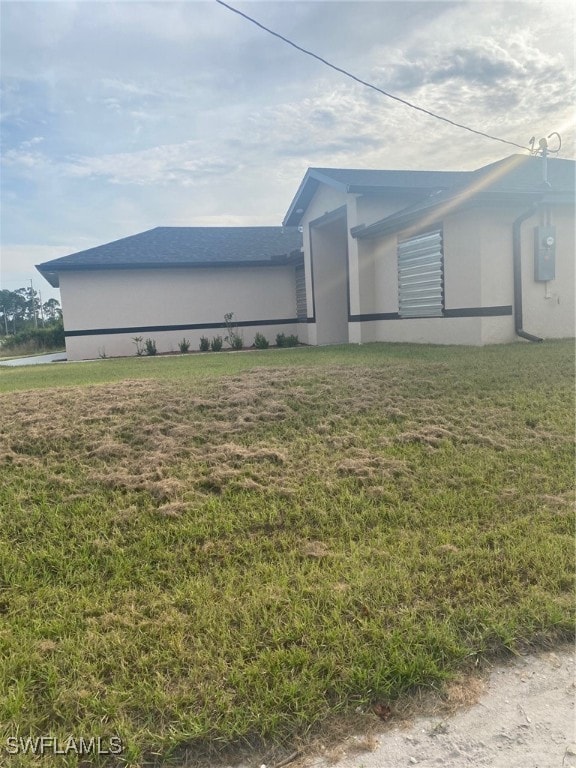 view of home's exterior featuring a lawn and electric panel