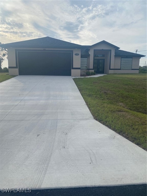 single story home with a garage and a front lawn