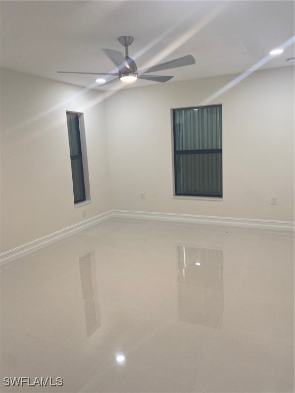 tiled spare room featuring ceiling fan