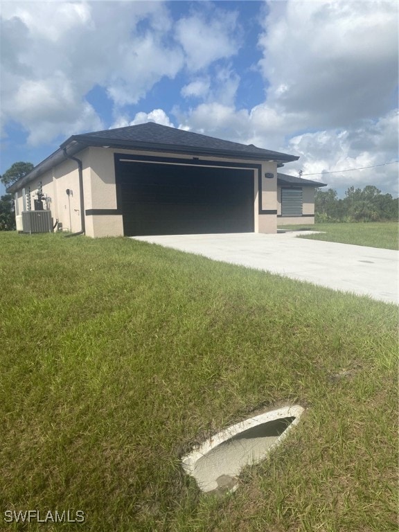 view of front of house with a front yard, a garage, and central air condition unit